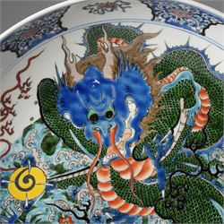 Chinese charger, decorated in blue, green and red enamels with a four clawed dragon chasing the flaming pearl amidst waves and flower heads, the rim with border of alternating reserves of auspicious emblems and flower scrolls, bearing apocryphal Kangxi mark beneath, D38cm 

