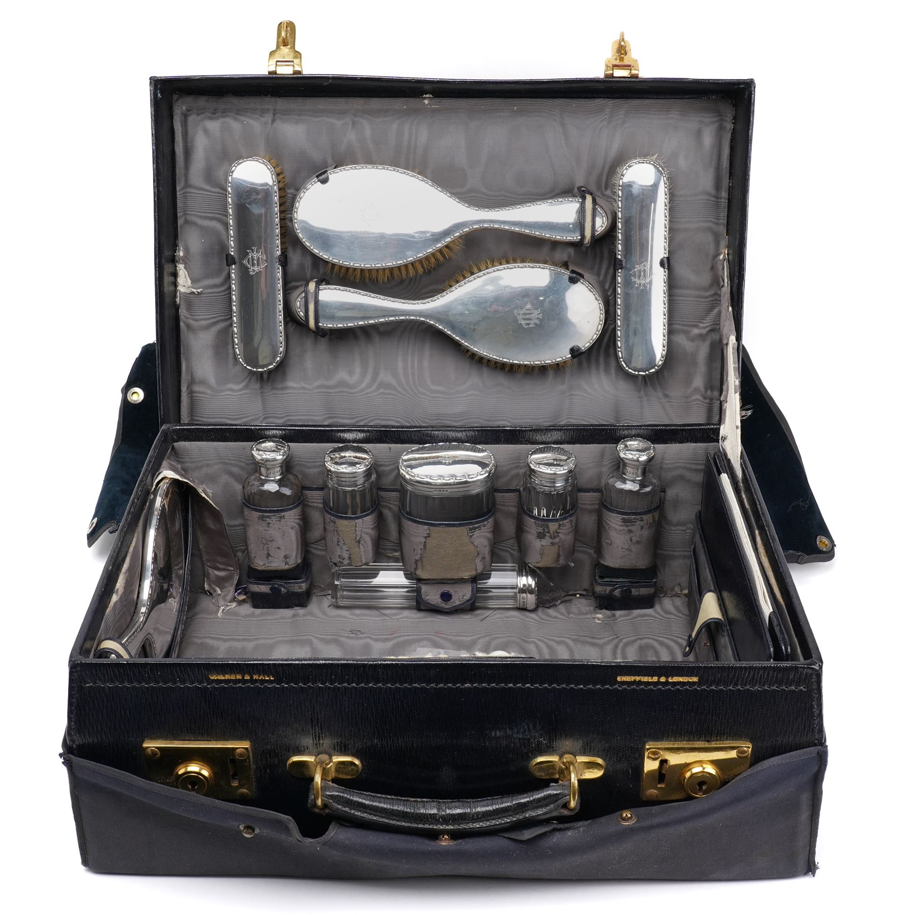 Early 20th century ladies leather travelling dressing case marked Walker & Hall, with watered silk interior and contents of silver mounted glass jars, dressing table set, leather blotter etc and with outer canvas London 1921/22 Maker Thomas Ingleton 46cm x 31cm 