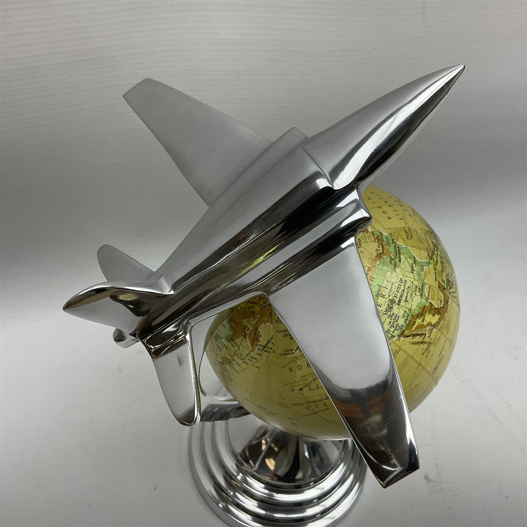 Art Deco style world globe with chrome aeroplane finial and mounts, H31cm