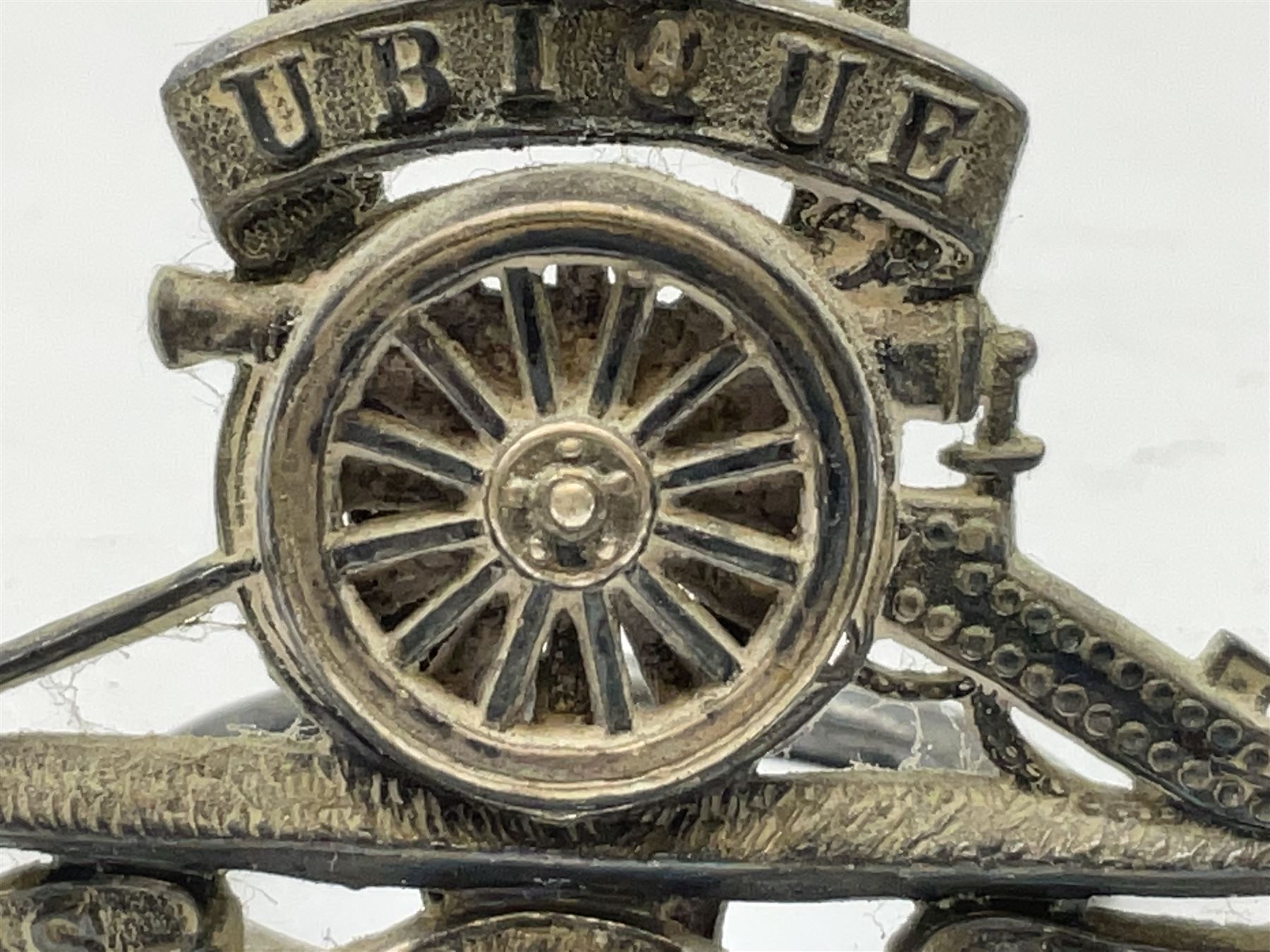 Trench Art - three WW2 brass shell case ashtrays, one mounted with Royal Artillery cap badge and button and one mounted with RA button; together with a pair of place name holders each formed from a Royal Artillery cap badge (5)