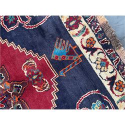 Persian rug, red ground field decorated with stylised flower heads and bird motifs, floral scrolling border