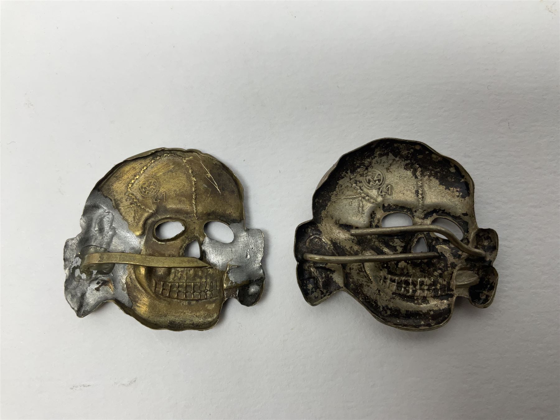 Five German 'SS' visor cap metal badges comprising one eagle and four skull and cross-bones (5)