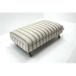 Footstool upholstered in a pale gold ground fabric with floral pattern