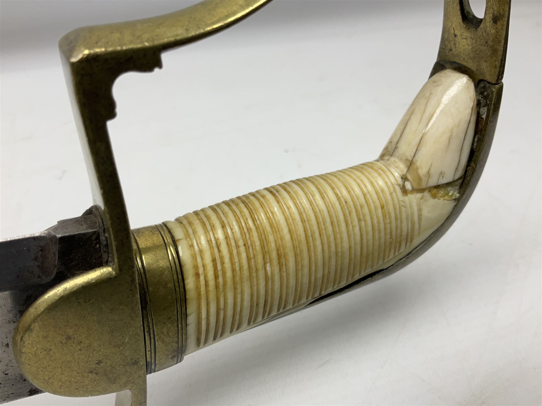 British pattern 1796 Light Cavalry Officer's sword, the 83.5cm curving steel blade marked 'W. Parker London' and 'Warranted' verso, brass stirrup hilt with half-round langets, knucklebow and backstrap with ribbed ivory grip; in brass mounted leather covered scabbard with two suspension rings L97cm overall. This item has been registered for sale under Section 10 of the APHA Ivory Act 