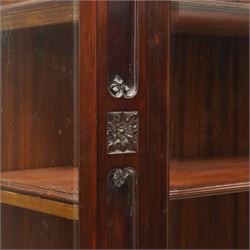 Large and impressive 19th century heavily carved mahogany display cabinet, the ornate pediment carved with a central scalloped and foliate rocaille motif with extending acanthus leaves and egg-and-dart moulding flanked by acanthi finials, over a central cartouche with carved bow-and-arrow motif and trailing scrollwork, the bookcase enclosed by two glazed doors with bevelled glass sides, the base with a gadrooned upper edge over a central rocaille ornament with scrolling acanthus leaves, the panelled frieze with further foliate motifs, raised on large carved snarling lion mask supports with floral garlands and claw feet, united by a concave rectangular platform base with gadrooning egg-and-dart moulding