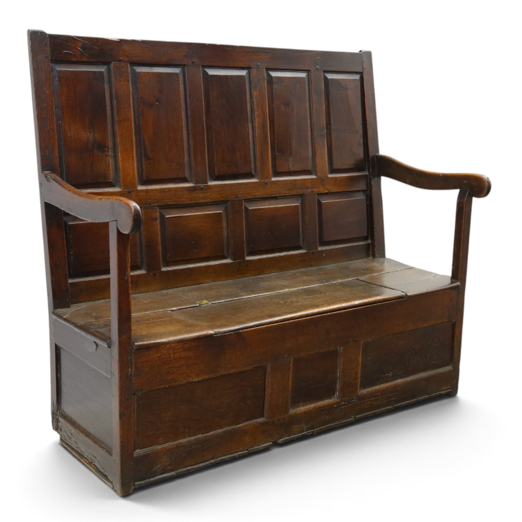 18th century oak high-back settle or hall bench, the panelled back and arm terminals over a hinged box seat, panelled front on short stile feet