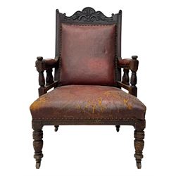 Victorian walnut framed armchair, shaped pediment carved with scrolling foliage, upholstered in leather, on ring turned front feet