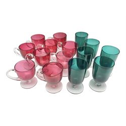 Collection of 19th century coloured glasses, to include nine cranberry glass punch cups, each with clear glass handle and foot and a set of six green glasses, with short clear stems, tallest H10cm