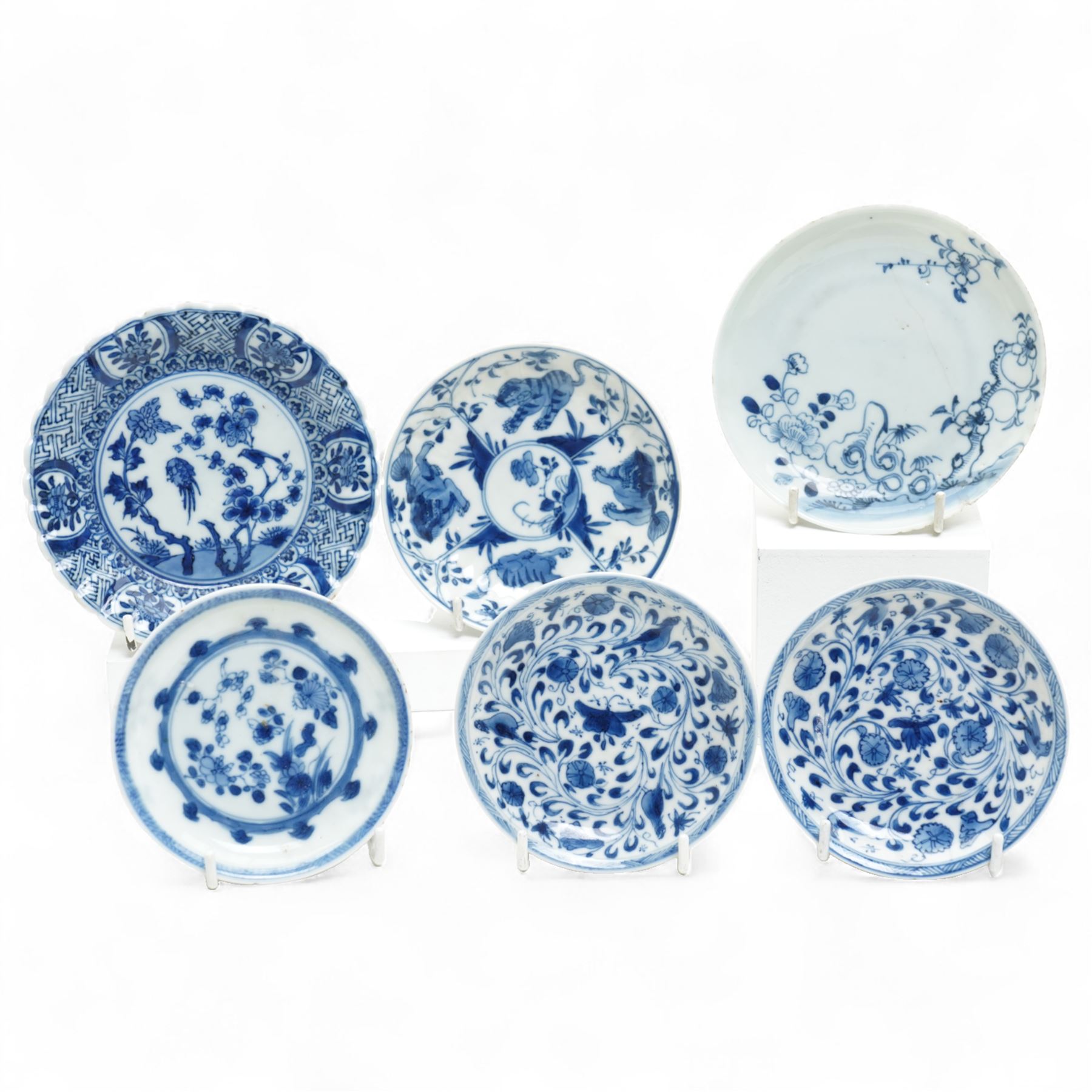 Set of six Chinese blue and white saucers, mostly Kangxi period, comprising matching pair decorated with insects and birds, example with painted lions and tigers, four bearing blue painted 'lingzhi' fungus mark to base, the others unmarked (6)