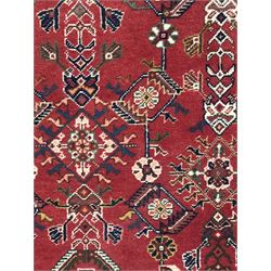 Persian Qashqai crimson ground runner, the central field decorated with three large geometric medallions with intricate angular and floral motifs, the indigo spandrels with complementary geometric designs, bordered by an ivory band with repeating floral patterns and angular vines