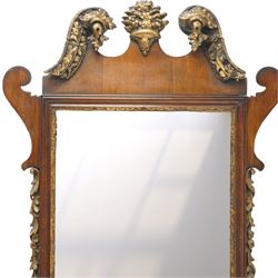 19th century Chippendale design mahogany fret mirror, broken swan neck pediment of foliate design with century bouquet in gilt finish, the rectangular bevelled plate flanked by trailing bellflower motifs, over a shaped terminal
