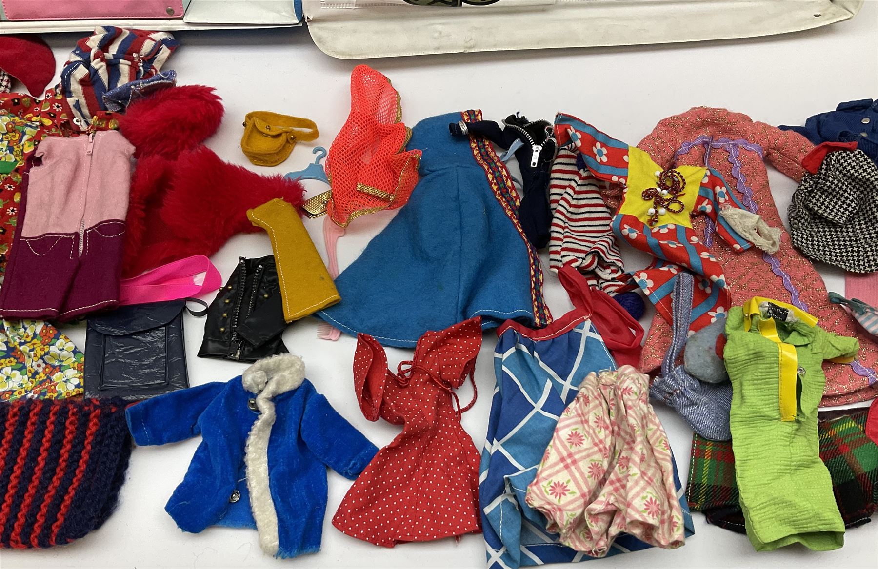 The World of Barbie Double Doll Case containing a quantity of assorted doll's clothing; together with two large and one small fashion dolls.