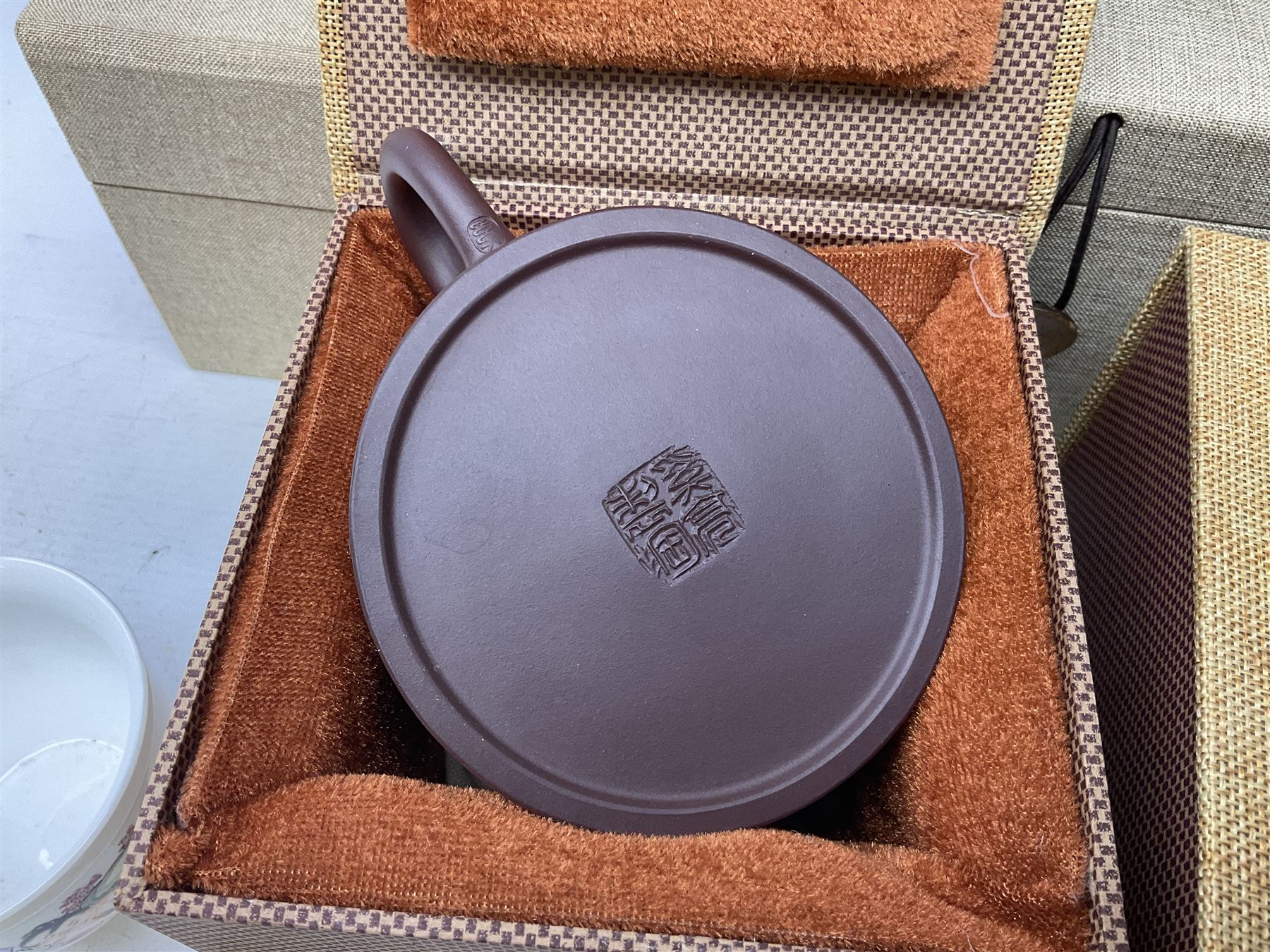 Two Chinese Yixing teapots, Chinese tea bowl hand painted with figures reading, another tea bowl with with underglaze floral panel and another tea bowl with saucer and lid, together with other teacups etc all boxed and with character marks