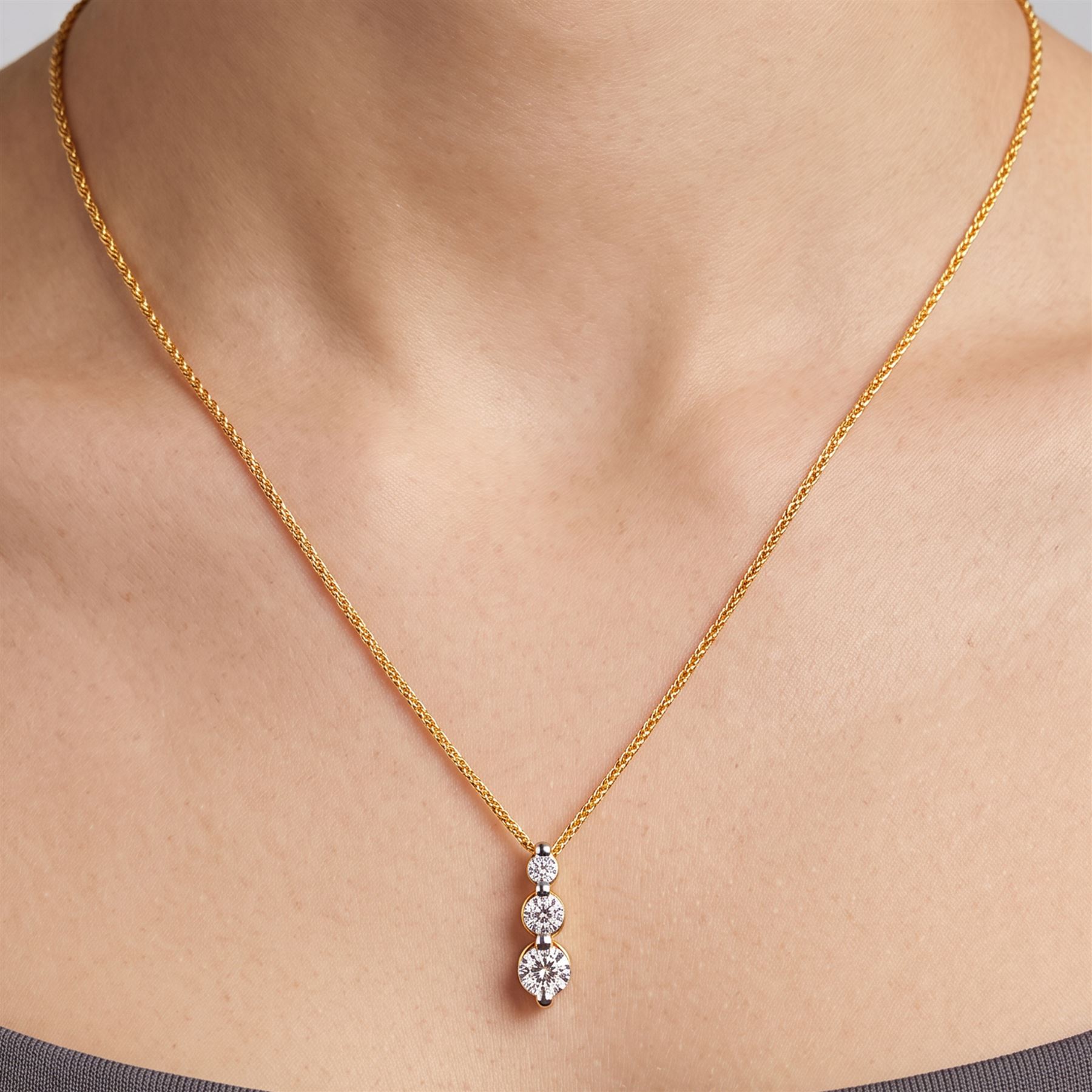 18ct gold diamond pendant necklace, set with three graduating round brilliant cut diamonds, total diamond weight 0.25 carat