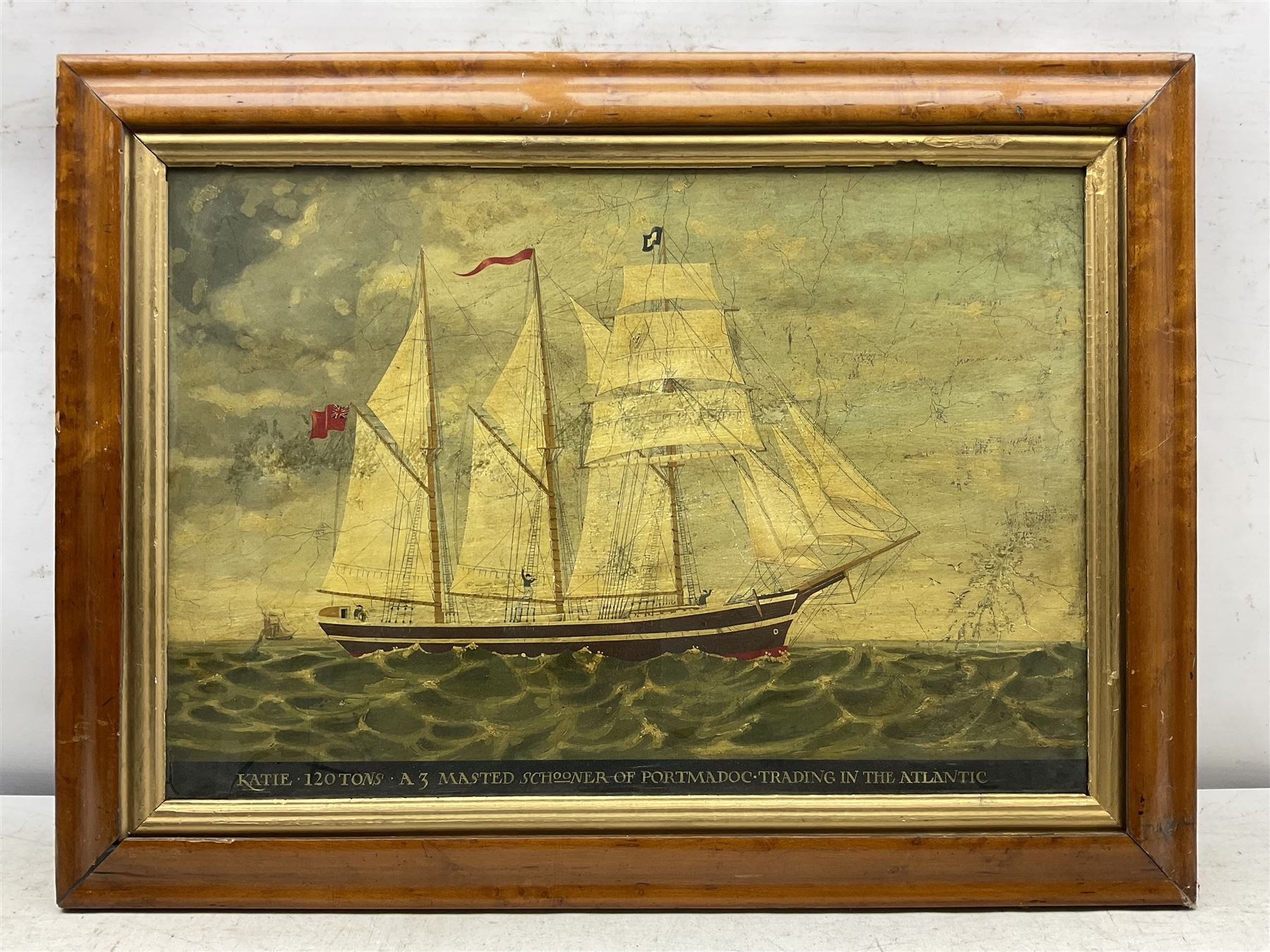 English School (20th Century): 'Katie 120 Tons - A Three Masted Schooner of Portmadoc Trading in the Atlantic', oil on panel titled along the lower edge 39cm x 57cm in birdseye maple veneered frame