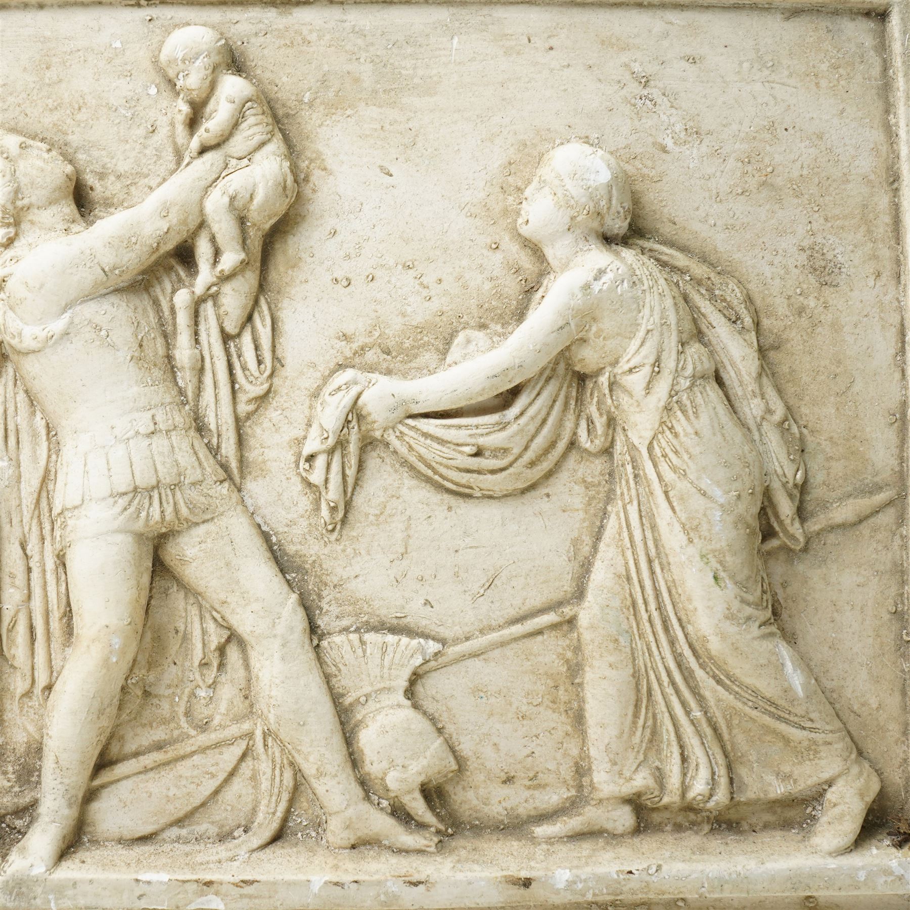 After the Antique - Relief moulded plaster plaque of Roman figures, one holding a child aloft 31cm x 55cm