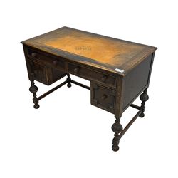 Early 20th century Jacobean design oak desk, with rectangular top inset with worn tooled leather, two frieze drawers over pedestals each fitted with a pair of panelled drawers, turned handles, on carved and fluted tapering legs united by stretchers 