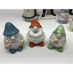 Group of eleven Aquincum of Budapest figures, comprising two of a man in a feather hat, seven dwarves, man and woman in traditional dress, all with printed marks beneath