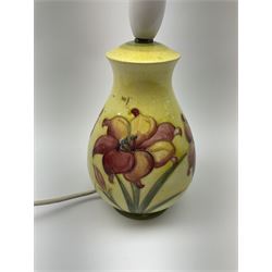 A Moorcroft table lamp, of baluster form, decorated in the African Lilly pattern, with impressed and painted marks, and paper label beneath, excluding fixtures H19.5cm.