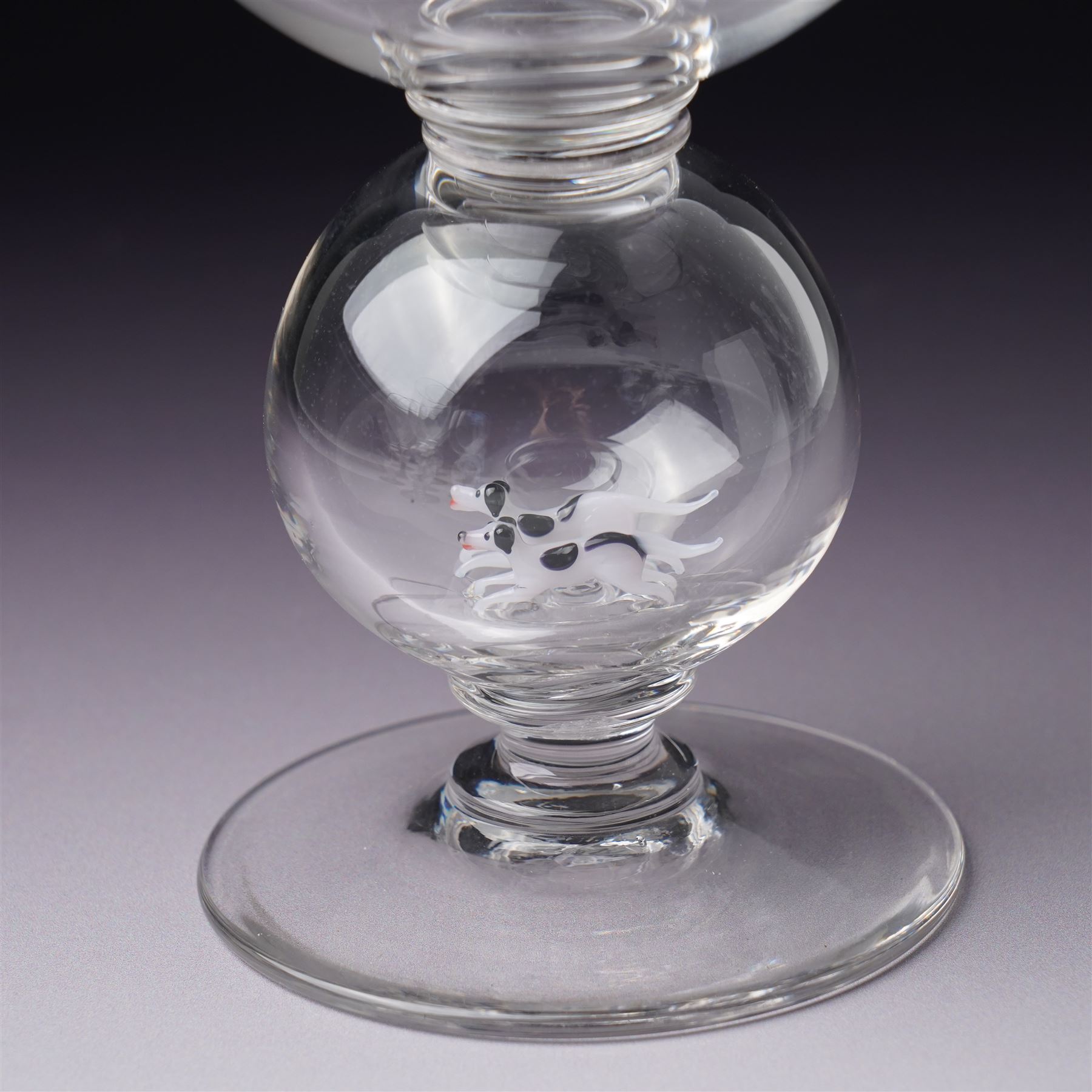 Set of six 1930s glass goblets by William Swingewood for Stevens & Williams, each goblet with lampwork glass stem, the large hollow blown knop containing dog, pair of hounds, horse, raven and two with flowers, H18cm (6)
