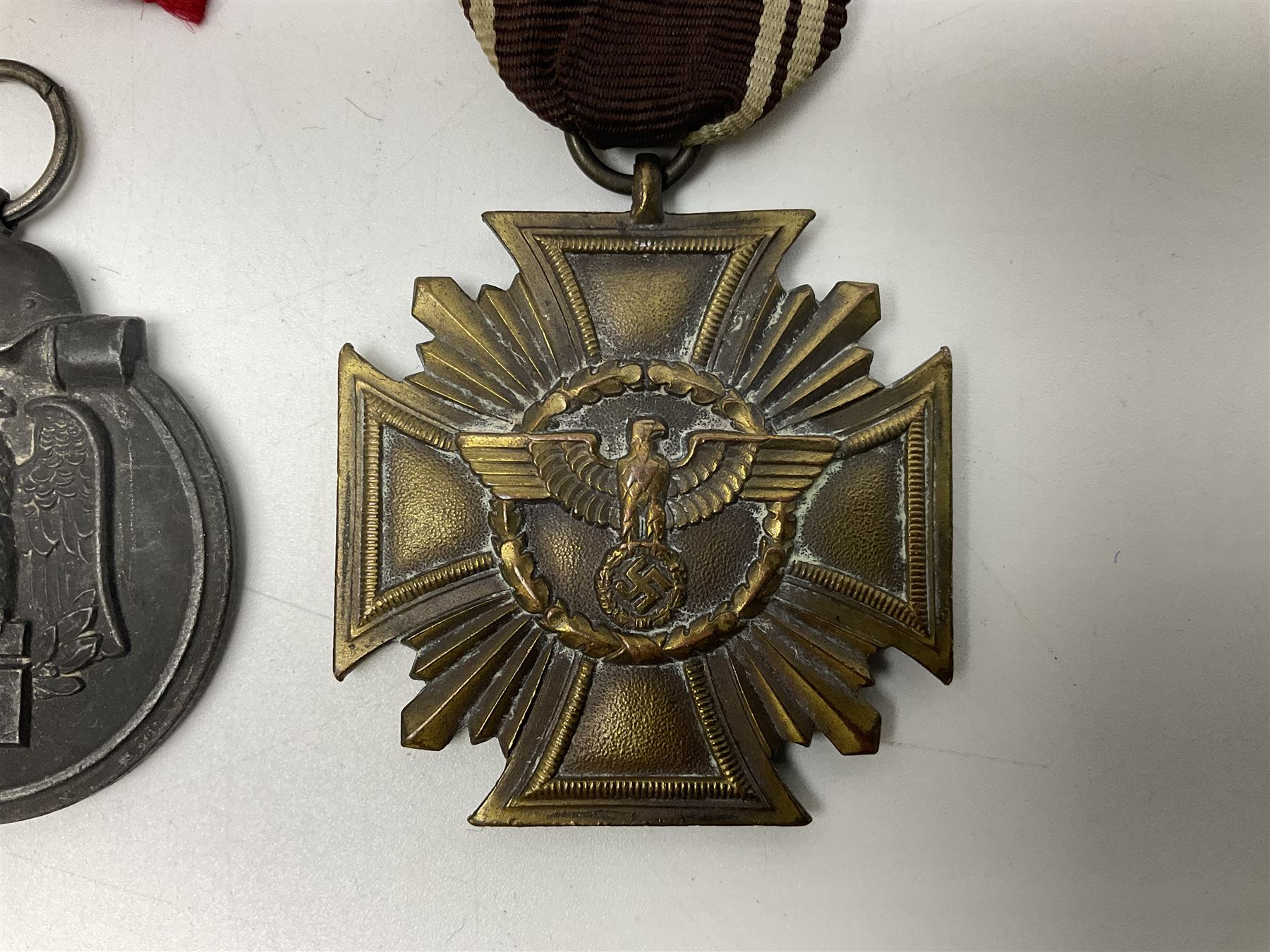 WW2 German Eastern Front Medal awarded to those who served on the German Eastern/Russian Front during the Winter Campaign period of 15th November 1941 to 15th April 1942 with original ribbon; German War Merit Cross with swords; and NSDAP Long Service Award (3)
