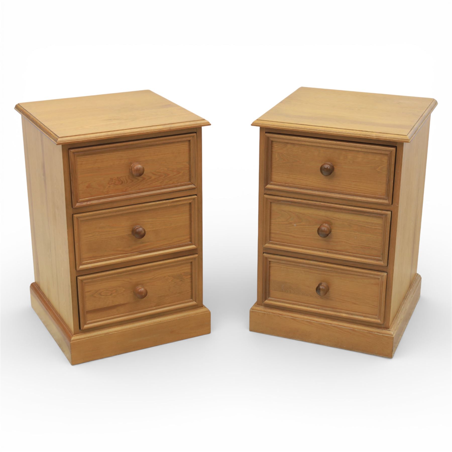Pair of late 20th century waxed pine bedside chests, three drawers with moulded edges and turned pulls, raised on a plinth base 