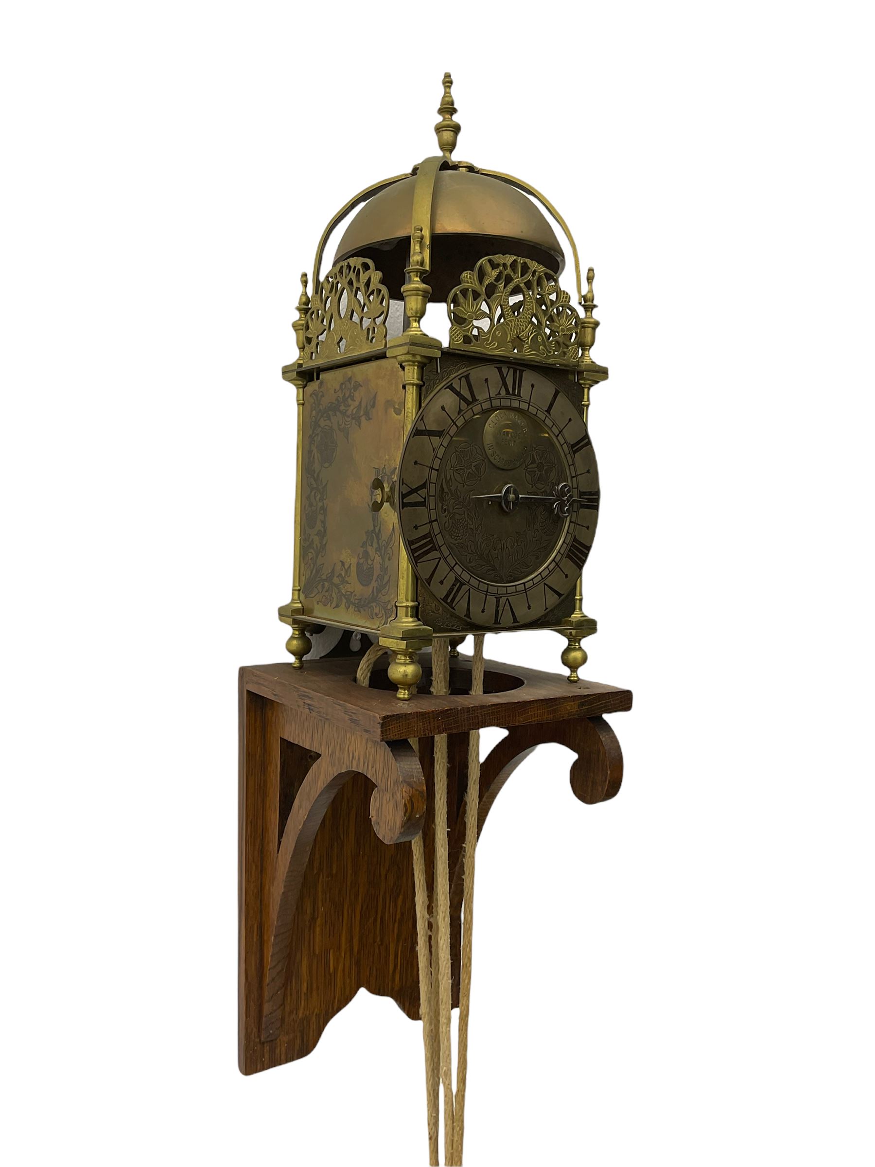 A 20th century replica of a 17th century 30-hour lantern clock with a rope driven verge escapement and countwheel striking, sounding the hours on a bell, with an engraved dial centre, silvered chapter ring and Roman numerals , half hour and quarter hour markers and a pierced and fettled steel hand, with an attached disc engraved “ Clockmaker In Scarborough Ivan Coe, Fecit,”, with engraved side doors, brass finials and dolphin fretwork, on a wooden bracket with pulley.   No weight.
Clocks similar to this were usually individually constructed by engineers working from plans of clocks designed by Claude Reeve, John Wilding, Malcolm Timings and other well-known clockmakers/engineers. 
