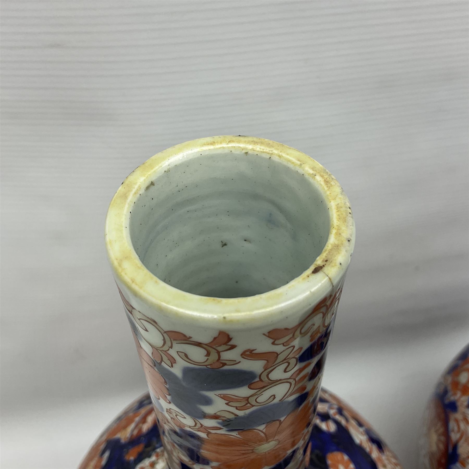 Pair of large 19th century Japanese Imari porcelain bottle vases, painted with shaped reserves of peonies, chrysanthemums and prunus blossom, each H46cm