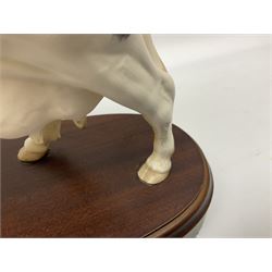 Beswick Connoisseur model of a Charolais Bull, on wood plinth, together with Royal Doulton matt Friesian cow, on wooden plinth, both with printed mark beneath 
