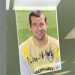 Pair of 1990s Leeds United goalkeeper's gloves signed by Nigel Martyn and Paul Robinson, mounted in a wall hanging framed display with signed pictures of each player 60 x 55cm. Provenance: the vendor was a coach at the keepers' club Leeds United and the gloves were signed for him.