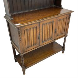 Early to mid-20th century oak dresser, raised two tier plate tack over two linenfold panelled doors, on spiral turned supports united by undertier 