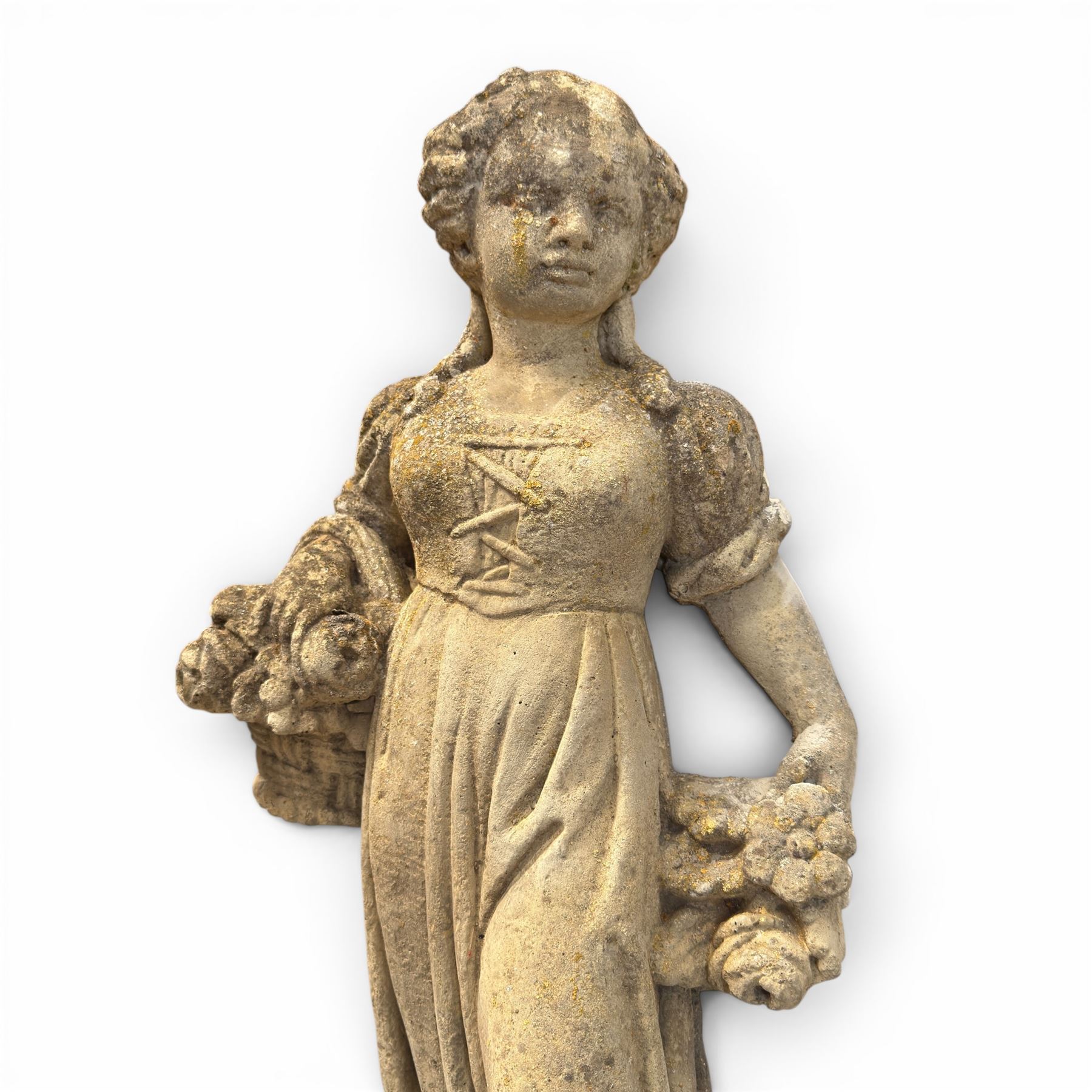 Lucas Stone - pair of cast stone garden figures, modelled as young female figures holding wheat sheafs and baskets of flowers, each on square bases, weathered finish, makers mark stamped to base