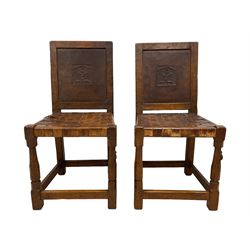 Mouseman - circa. 1930s set of six (4+2) oak dining chairs, panelled back carved with the Bagshawe family crest, the moto 'Forma Flos Fama Flatus' over an arm grasping a bugle-horn with ribbon tie and Yorkshire rose motif, adzed frame, leather lattice strap seat, on octagonal supports united by stretchers, two carvers and four side chairs, each carved with mouse signature, by Robert Thompson of Kilburn 

Provenance: Owned since manufacture by the Bagshawe family, descendants of the Staithes Group Artist Joseph Richard Bagshawe RBA (1870-1909).