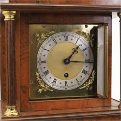 Early 20th century walnut small longcase clock, brass dial with silvered Roman numeral chapter ring and pierced black hands, the figured walnut case with shaped projecting hood, long moulded trunk door and stepped plinth base