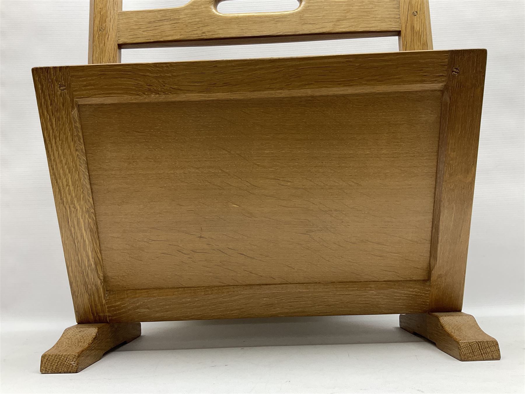 Mouseman - oak magazine rack, the top rail pierced with handle and carved with mouse signature, octagonal supports with two panelled and splayed sides, on sledge feet, by the workshop of Robert Thompson, Kilburn 