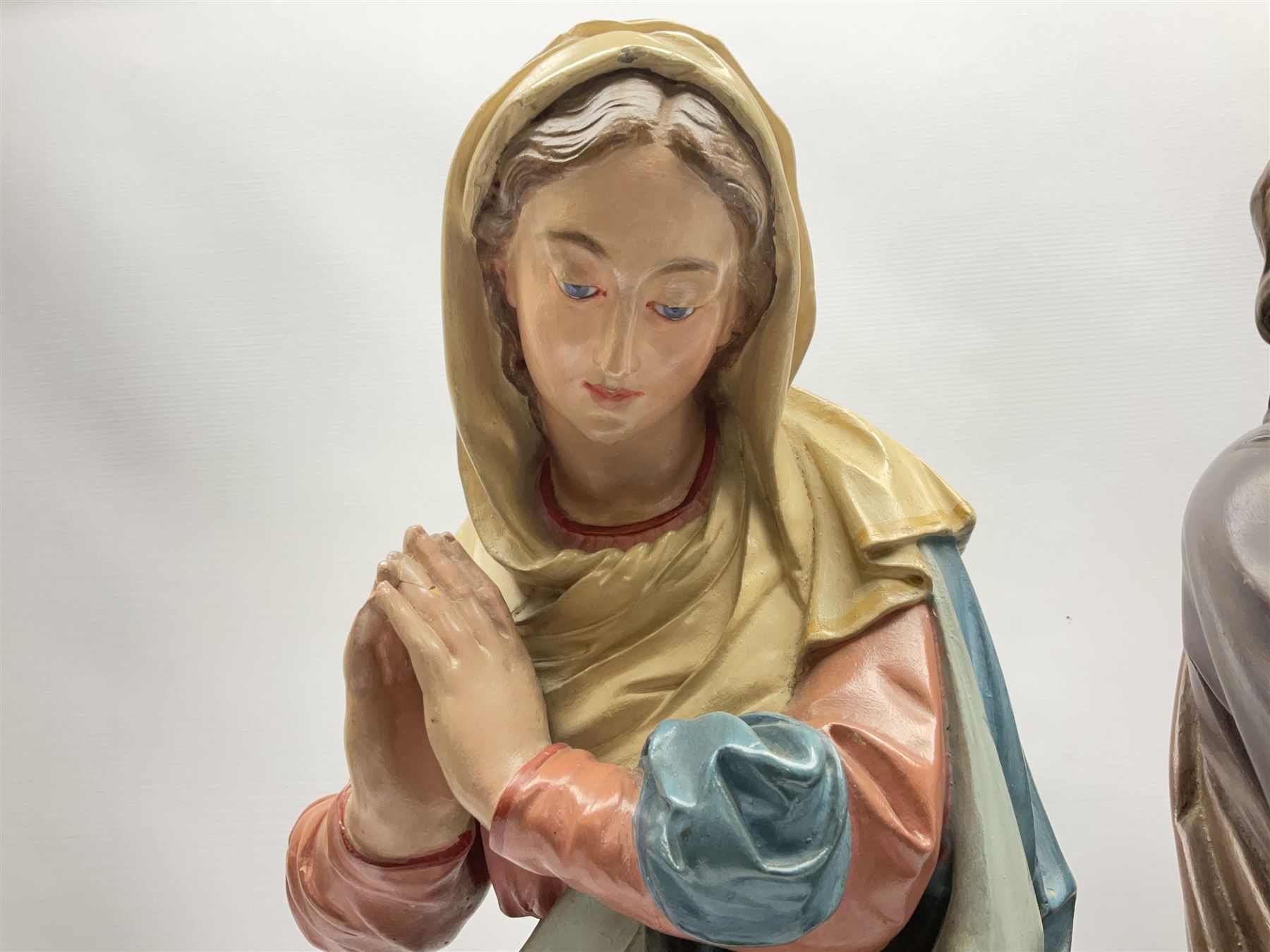 Two religious painted plaster figures of Mary and Joseph kneeling on oval plinths, with impressed mark 'Raffl et Cie Paris', H60cm 