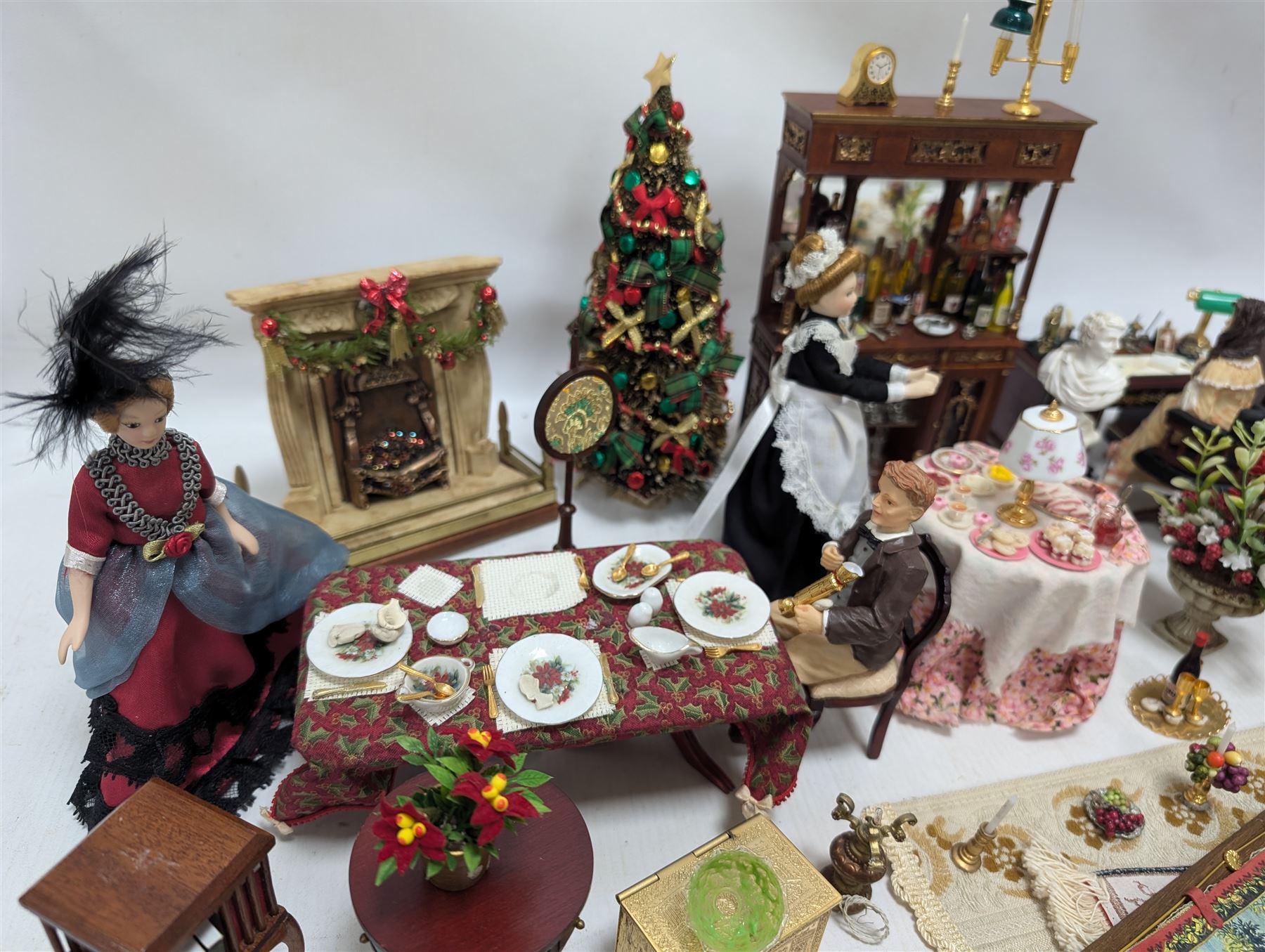 Dolls house living room and dining room furniture, including arm chairs, desk, fireplaces, dressers, tables, eight figures and a large collection of predominantly Christmas themed food, accessories and decorations