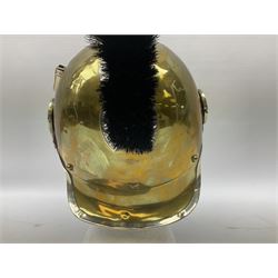 Early 20th century French mounted gendarme's helmet, brass with nickel-silver mountings, broad band embossed with fused grenade, high comb with the face of the gorgon Medusa at the peak and with a black horse hair crest, plume socket at the left, leather-backed nickel-silver chin scales with lion mask mounts.