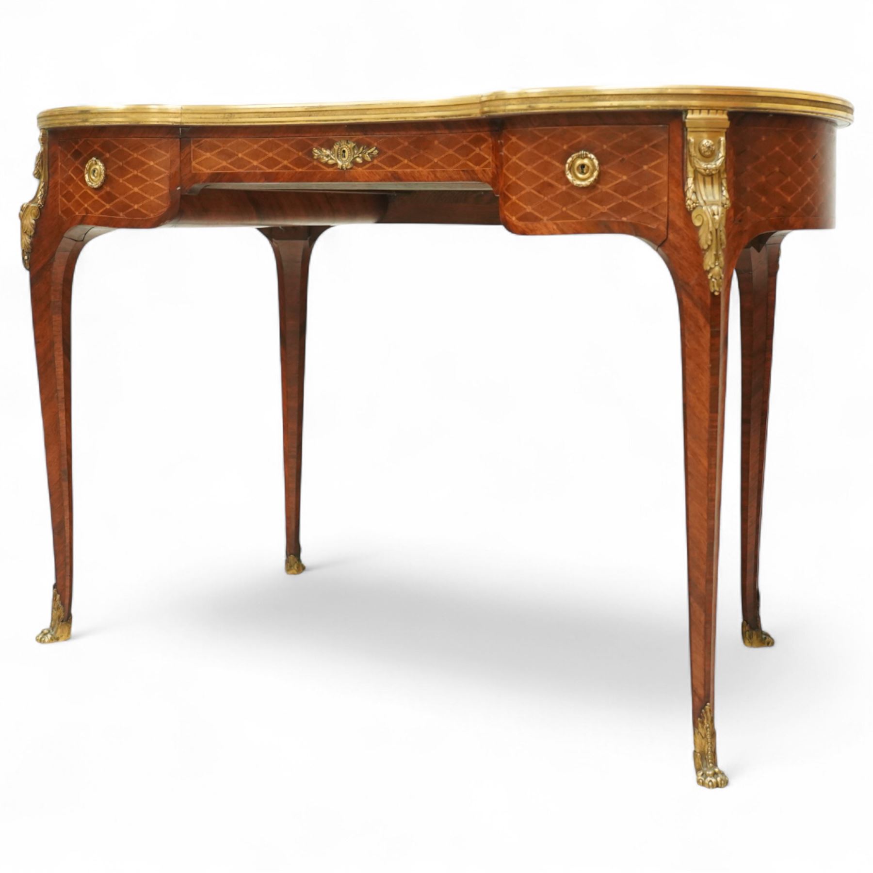 Late 19th-century Louis XV-style marquetry and gilt bronze-mounted kidney-shaped writing table, of serpentine form, top finely veneered with a trellis parquetry pattern, within a gilt bronze moulded edge, above a shaped frieze fitted with a central drawer flanked by two short drawers, similarly inlaid side and legs, knees with gilt bronze foliate mounts and cabriole legs terminating in gilt bronze sabots