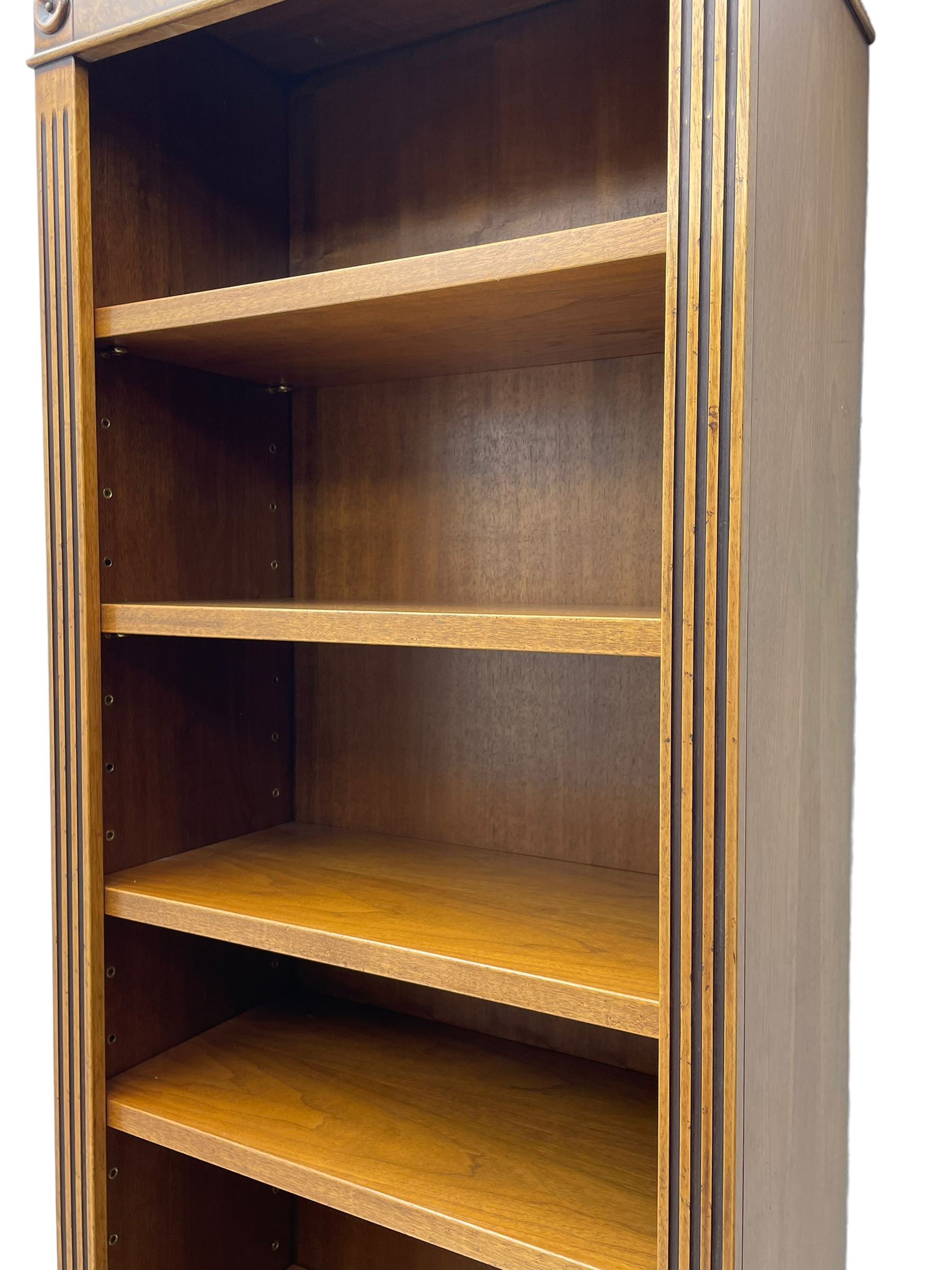 Georgian design walnut open bookcase, projecting cornice over figured banded frieze flanked by roundels, fitted with six adjustable shelves with flanking fluted uprights, on skirted base