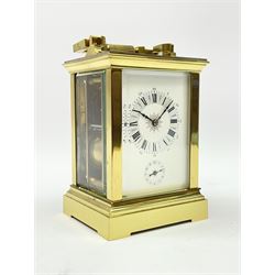 Early 20th century brass and bevelled glass repeater carriage clock with alarm, the angular and cylindrical ribbed handle and repeater button over stepped cavetto cornice, white enamel Roman dial with Arabic subsidiary alarm set dial, twin train eight day movement striking the hours and half on coil, separate alarm mechanism train, stepped moulded and plain faced base, with leather travelling case
