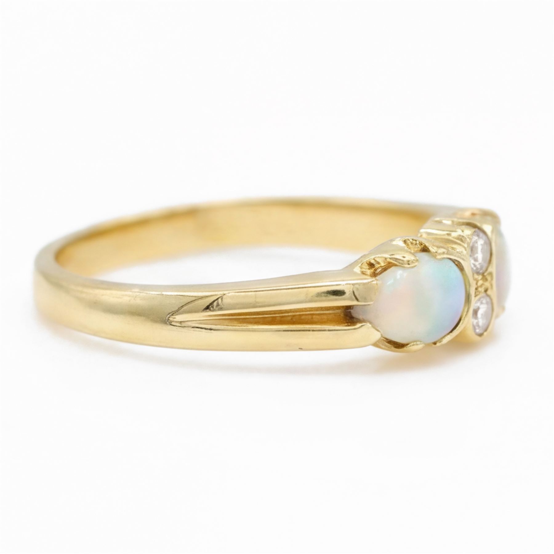 18ct gold opal and diamond four stone ring, two round brilliant cut diamonds, with a single cabochon pear cut opal set either side, London 1994