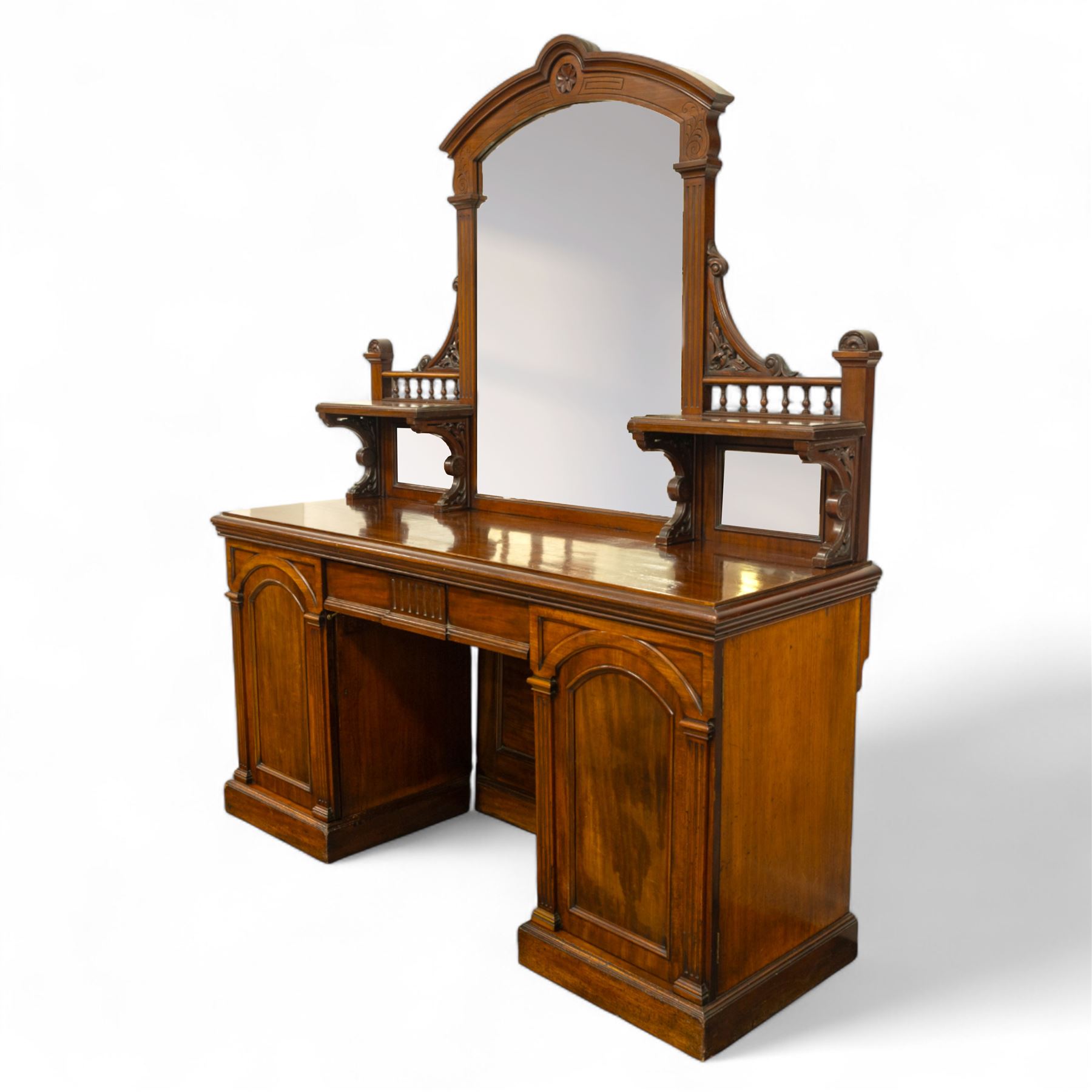 Late 19th century mahogany twin pedestal mirror back chiffonier, stamped James Winter of London, the arched mirrored back flanked by turned gallery shelves above a rectangular top, the base fitted with a pair of arched panelled cupboard doors, on a plinth base