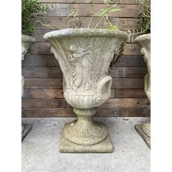 Set of four Victorian design cast stone Grecian urns, tapering form cast with figures and handles, square plinth bases