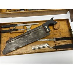 Naval doctor's surgical instruments, contained in a converted brass bound oak pistol box, the hinged lid opening to reveal two removable fitted trays, containing 19th century and later saws, scalpels, tweezers etc