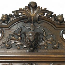 Large mid-19th-century Victorian rococo revival carved oak overmantel mirror, the rectangular mirror frame carved in high relief,  arched and scrolled pediment surmounted by a central foliate spray with acanthus scrolls above a finely carved classical mask, frieze decorated with symmetrical  acanthus scrolling, vertical uprights carved with trailing foliage, flowers, and ribbon-tied elements, terminating on a square supports 