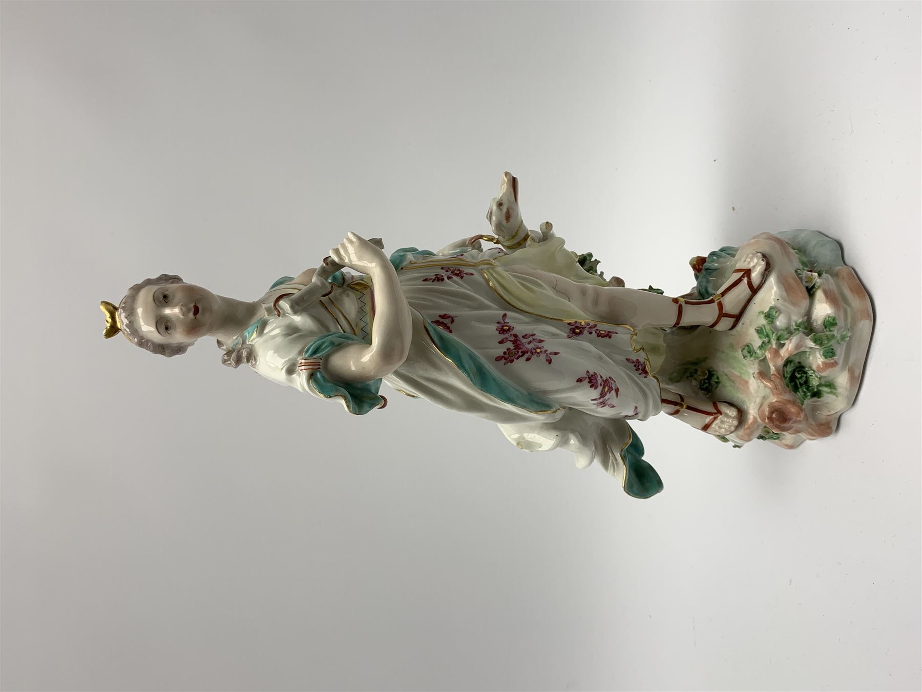 Mid 18th century Derby porcelain figure modelled as Dianna the Huntress, with quiver of arrows upon her back and dog by her side, upon a naturalistically modelled base, with patch marks beneath and collectors labels, H26cm