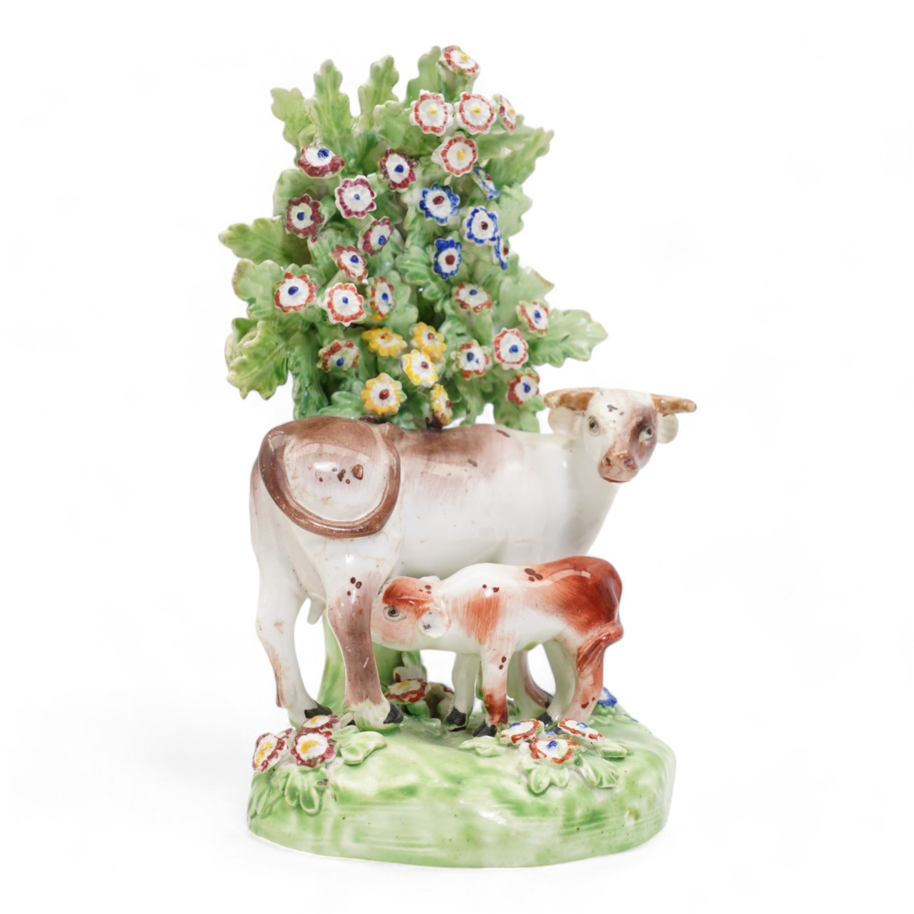 Two 18th century Derby porcelain groups modelled as a ram standing before bocage above a recumbent lamb, upon flower encrusted base, H15cm and two further Derby figures modelled as a ram and cow and calf (3)