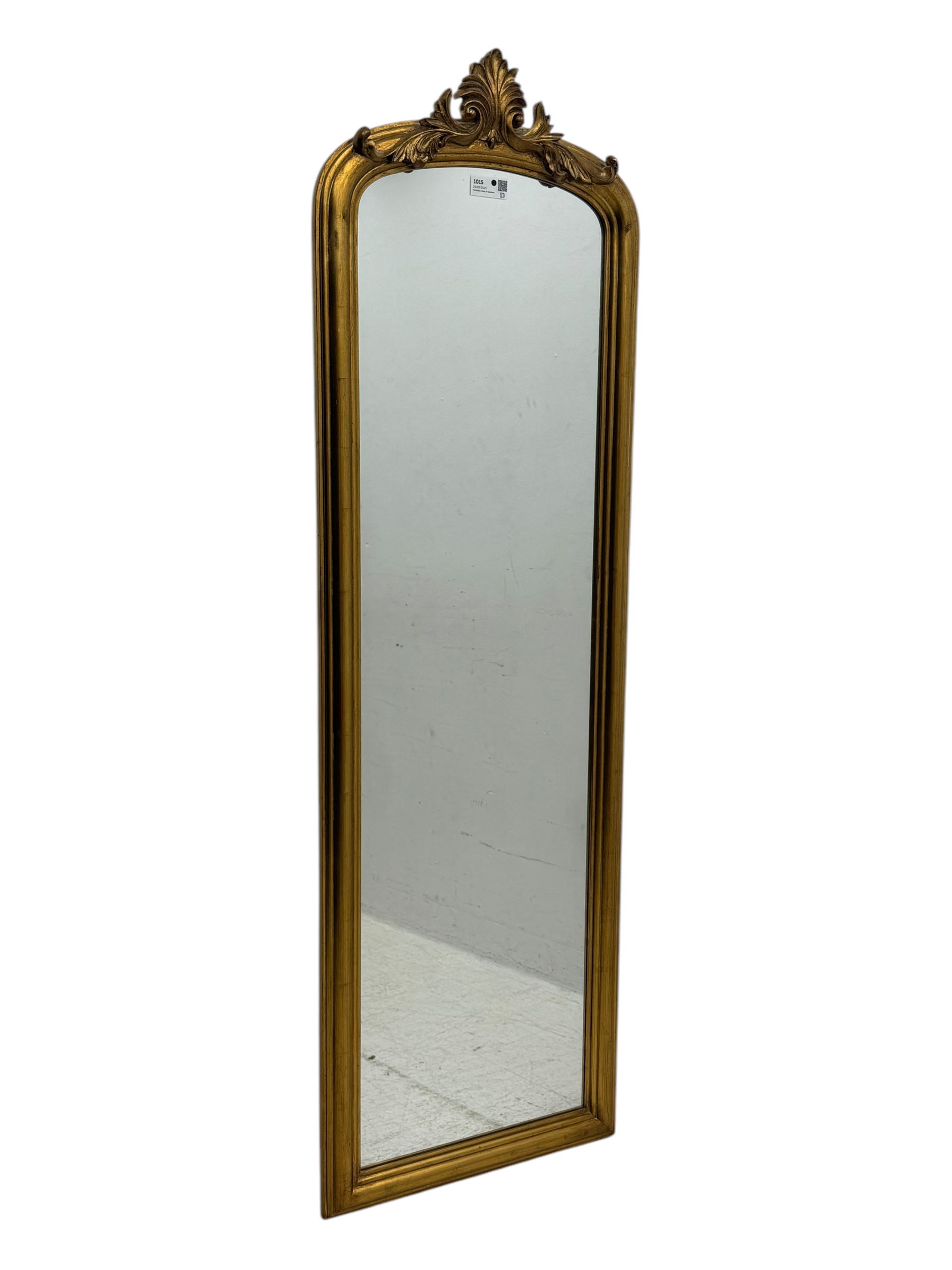 Narrow Victorian design gilt framed wall mirror, anthemion and scrolled acanthus leaf pediment over moulded frame, plain mirror plate 