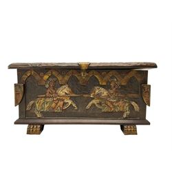 Carved wooden blanket chest, the tooled hinged lid with shaped metal strap hinges and catch, the front carved with arcade over two medieval jousters, on carved sledge feet